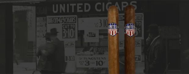 Two United Maduro cigars, known for their rich flavors of black espresso, black licorice, cocoa powder, and black olives, stand against a vintage cigar shop backdrop. Each cigar features a bold United Cigars band, highlighting its premium craftsmanship."