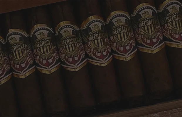 Firecracker premium cigars in a wooden box, featuring bold patriotic bands with eagle and shield design — full-bodied handmade cigars crafted for robust flavor and standout presentation.