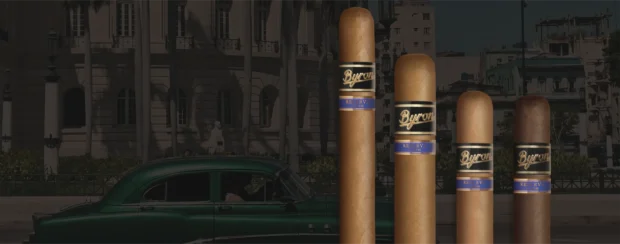 Byron Reserva 21st Century cigars displayed in varying sizes with elegant black and gold bands labeled 4 Años, set against a backdrop of a classic green car and old Havana architecture.